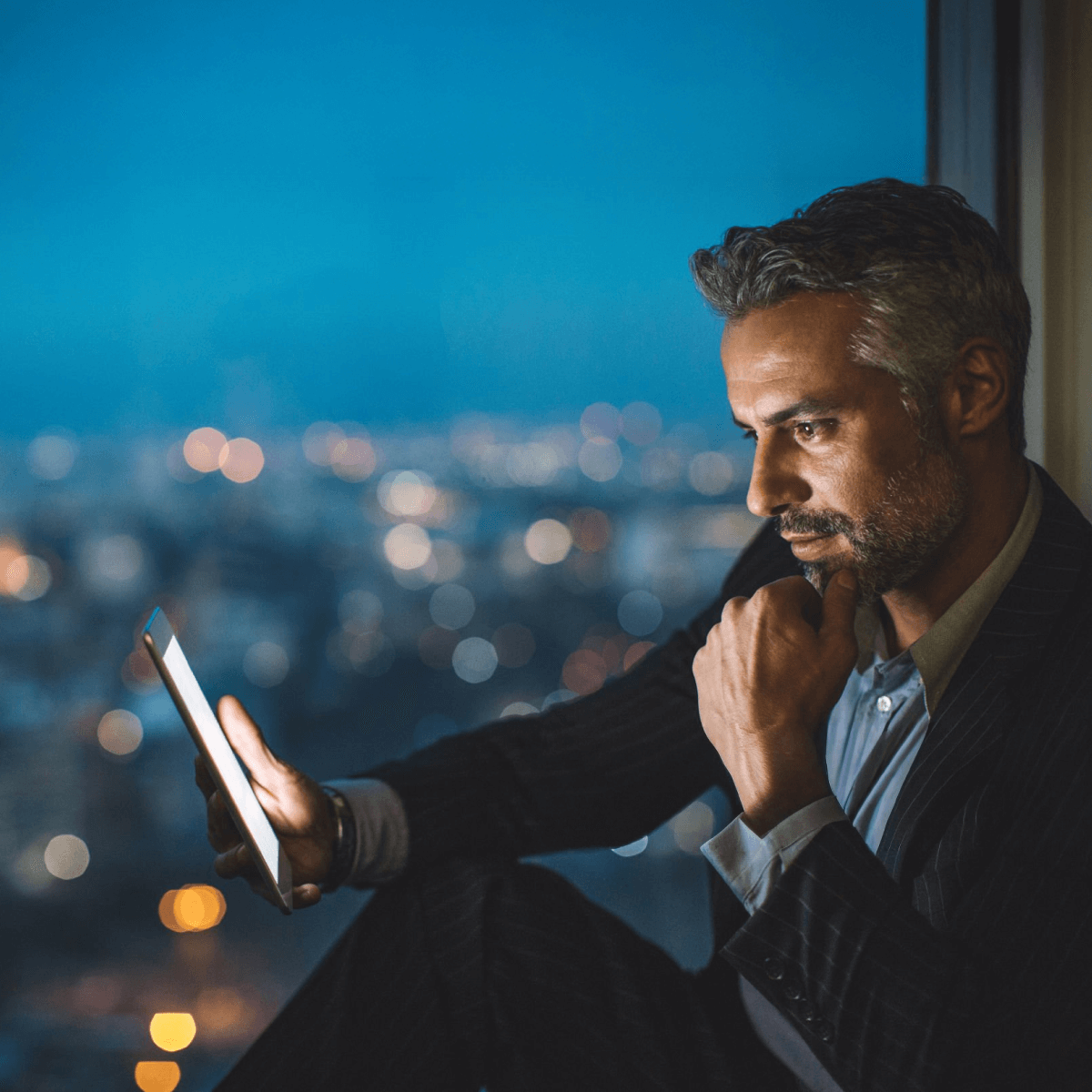 moški ponoci gleda na tablico na balkonu